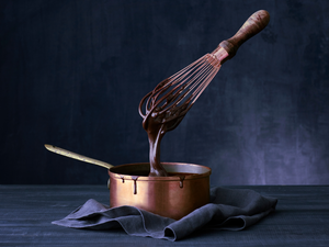 A photo of a luxuriously thick chocolate paste being whisked in a cooper saucepan.